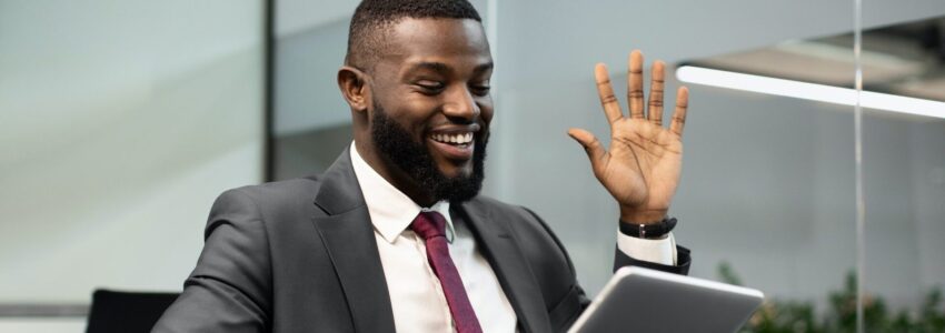 Happy black businessman having video chat, using digital tablet